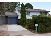 Two-story home featuring a blue garage door, front yard landscaping, and a traditional-style mailbox at 14702 E Security Way, Aurora, CO 80011