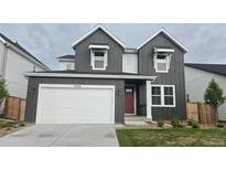 Charming two-story home featuring vertical siding, a red front door, and a pristine white garage door at 9324 Quartz St, Arvada, CO 80007