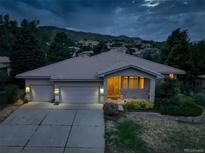 Charming single-story home featuring a tile roof, manicured front yard, and a convenient three-car garage at 6379 Spotted Fawn E Run, Littleton, CO 80125