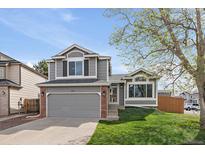 Charming two-story home with grey siding, brick accents, a well-manicured lawn, and an attached two-car garage at 292 S Pembrook St, Castle Rock, CO 80104