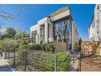 Modern two-story home with a combination of white stone and wood-paneled accents at 427 Milwaukee St, Denver, CO 80206