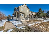 Two-story home with white picket fence, snowy yard, and sidewalk at 3805 Windriver Trl, Castle Rock, CO 80109