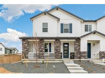 Charming two-story home featuring stone accents, white siding, and a welcoming blue front door at 5788 N Killarney Way, Aurora, CO 80019
