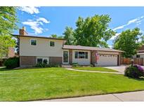 Charming two-story home with a well-manicured lawn, brick accents, and an attached two-car garage at 6143 S Ash E Cir, Centennial, CO 80121