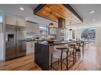 Modern kitchen features an island with bar seating, stainless steel appliances, and wood accents at 3135 W 25Th Ave, Denver, CO 80211