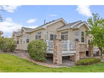 Lovely backyard showcasing a patio with stone pillars and white railings, surrounded by beautiful landscaping and green grass at 22312 E Plymouth Cir, Aurora, CO 80016