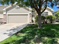 Charming home with a two-car garage, lush green lawn, and mature landscaping in a quiet neighborhood at 22312 E Plymouth Cir, Aurora, CO 80016