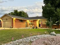 Brick ranch home with landscaped lawn, attached garage, and mature trees at 3300 E Briarwood Ave, Centennial, CO 80122