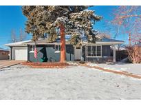 Ranch style home with snow-covered lawn and attached garage at 6125 Brentwood St, Arvada, CO 80004