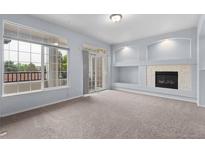 Bright living room with fireplace and access to a balcony through sliding glass doors at 12711 Colorado Blvd # 1116, Thornton, CO 80241