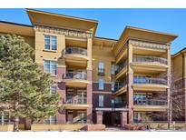 Three-story building with multiple balconies and a tree in front at 7820 Inverness Blvd # 308, Englewood, CO 80112