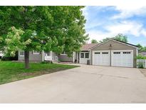 Charming single-story home with a well-manicured lawn, mature shade tree, and an attached two-car garage at 8525 Grandview Ave, Arvada, CO 80002