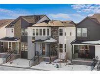 Modern two-story home with gray and white exterior, and snowy front yard at 7210 Watercress Dr, Littleton, CO 80125