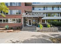 Inviting entrance of Gotham, a multi-story brick building, featuring modern architectural accents and landscaping at 1196 N Grant St # 407, Denver, CO 80203