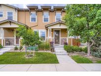 Inviting townhome entrance with stone accents, lush landscaping, and a well-maintained lawn at 1519 S Dayton St, Denver, CO 80247
