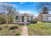 Charming green cottage with a welcoming front porch and a well-manicured lawn at 4476 S Lincoln St, Englewood, CO 80113