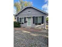 Charming bungalow style home with gray painted brick, dark shutters, and rock landscaping at 3818 W 14Th Ave, Denver, CO 80204