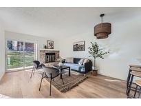 Bright living room featuring a brick fireplace, contemporary furniture, and a sliding glass door at 4294 S Salida Way # 4, Aurora, CO 80013