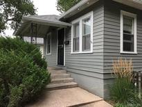 Charming home featuring gray siding, a cozy front porch, and manicured greenery at 150 S Garfield St, Denver, CO 80209