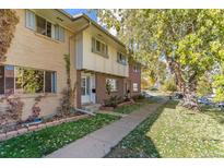 Charming brick townhome featuring mature trees and a well-maintained front yard in a quiet neighborhood at 12520 W Virginia Ave, Lakewood, CO 80228