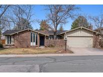Charming ranch-style home featuring a brick facade, attached garage, and well-maintained landscaping at 6551 E Heritage N Pl, Englewood, CO 80111