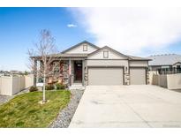 Charming home with a three-car garage, stone accents, and a well-maintained front yard at 7108 Morrison Dr, Frederick, CO 80530