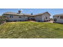 Well-manicured backyard featuring a spacious lawn, deck, and storage shed perfect for outdoor living at 7716 Shenandoah Dr, Elizabeth, CO 80107