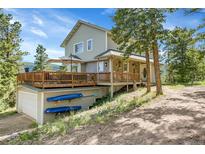 Charming two-story home featuring a spacious deck, garage, and kayaks, nestled in a natural setting at 6979 Weasel Way, Evergreen, CO 80439