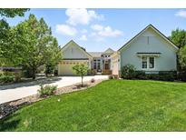 Charming home with a manicured lawn, mature trees, and a welcoming driveway leading to a two-car garage at 4944 W 107Th Loop, Westminster, CO 80031