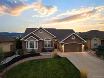 Charming home boasts stone accents, a two-car garage, and a well-manicured front yard at 444 Pasada Way, Monument, CO 80132