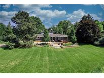 Expansive backyard view, featuring patio seating and lush landscaping at 5350 Yellowstone St, Bow Mar, CO 80123