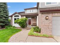 Charming brick home with a cozy front porch and landscaped garden for curb appeal at 6643 Orion Ct, Arvada, CO 80007