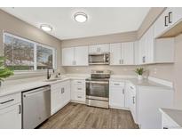 Modern kitchen features white cabinets, stainless steel appliances, and quartz countertops at 16038 E Oxford Dr, Aurora, CO 80013