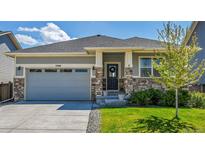 Charming single-story home with stone accents, well-maintained lawn, and attached two-car garage at 3086 Kestrel St, Brighton, CO 80601