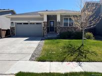 Charming single-story home featuring stone accents, a two-car garage, and well-maintained landscaping at 3086 Kestrel St, Brighton, CO 80601