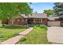 Charming brick home featuring a well-maintained front yard, landscaping, and an attached two-car garage at 1475 Kingsbury Ct, Golden, CO 80401