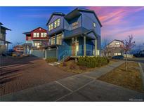 Charming two-story home featuring a well-manicured yard, brick driveway, and inviting front porch in a suburban neighborhood at 5295 Andes St, Denver, CO 80249