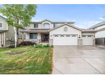 Charming two-story home with a three-car garage, covered porch, manicured lawn, and mature trees at 5146 S Argonne St, Centennial, CO 80015