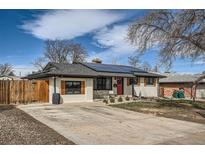 Charming home featuring solar panels, a red front door, wood shutters, and a well-kept front yard at 327 S Xanadu St, Aurora, CO 80012