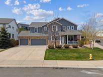 Charming two-story home with stone accents, three-car garage and inviting front porch at 3475 Golden Spur Loop, Castle Rock, CO 80108