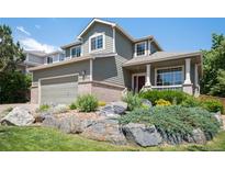 Inviting two-story home showcasing a well-maintained lawn and beautiful rock garden at 17235 Opal Hill Dr, Parker, CO 80134