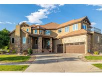 Beautiful, multi-story home with a three-car garage, stone accents, and manicured front lawn at 15501 Fairway Dr, Commerce City, CO 80022
