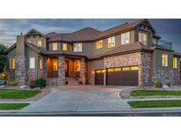 Stunning two-story home with a stone facade, a circular driveway, and a three-car garage at 15501 Fairway Dr, Commerce City, CO 80022
