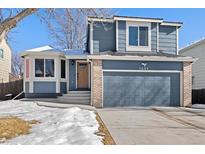 Two-story house with gray siding, a two-car garage, and a well-maintained lawn at 5603 W 118Th Pl, Broomfield, CO 80020