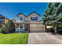 Charming two-story home featuring manicured lawn, a front porch, and attached two-car garage at 21238 Snowshoe Ln, Parker, CO 80138
