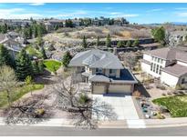 Beautiful home with stone accents, manicured landscaping, and a three-car garage, set against scenic surroundings at 5830 Jasper Pointe Cir, Castle Pines, CO 80108