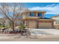 Charming two-story home with a three car garage and a well maintained front yard and beautiful rock landscaping at 5830 Jasper Pointe Cir, Castle Pines, CO 80108