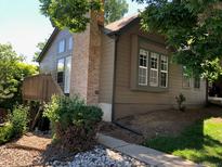 Charming exterior view with a deck, large windows, and brick chimney accenting the property's design at 17336 E Rice Cir # F, Aurora, CO 80015
