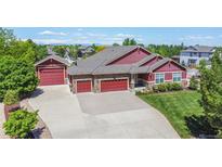 Stunning exterior elevation of this home with three-car garage, lush landscaping, and expansive driveway at 16283 Olive Way, Brighton, CO 80602