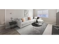 Bright living room featuring a white sectional sofa and coffee table at 384 S Decatur St, Denver, CO 80219